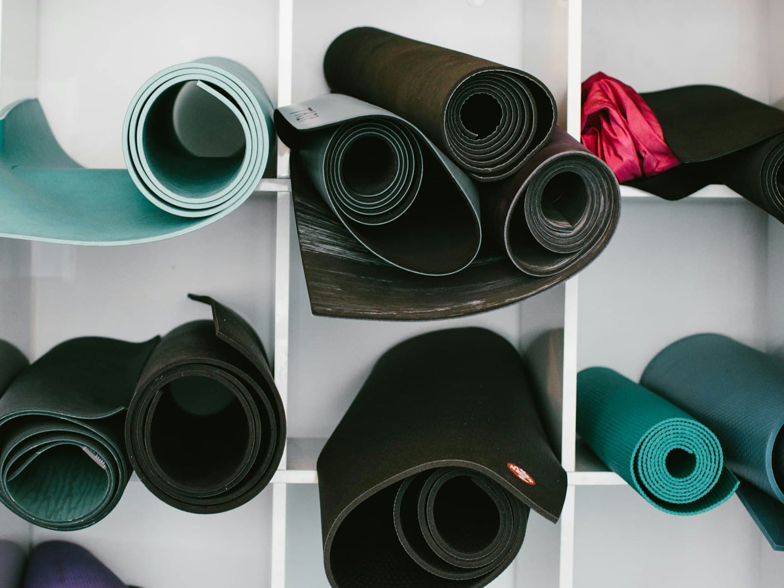 Rolled yoga mats stored on a shelf