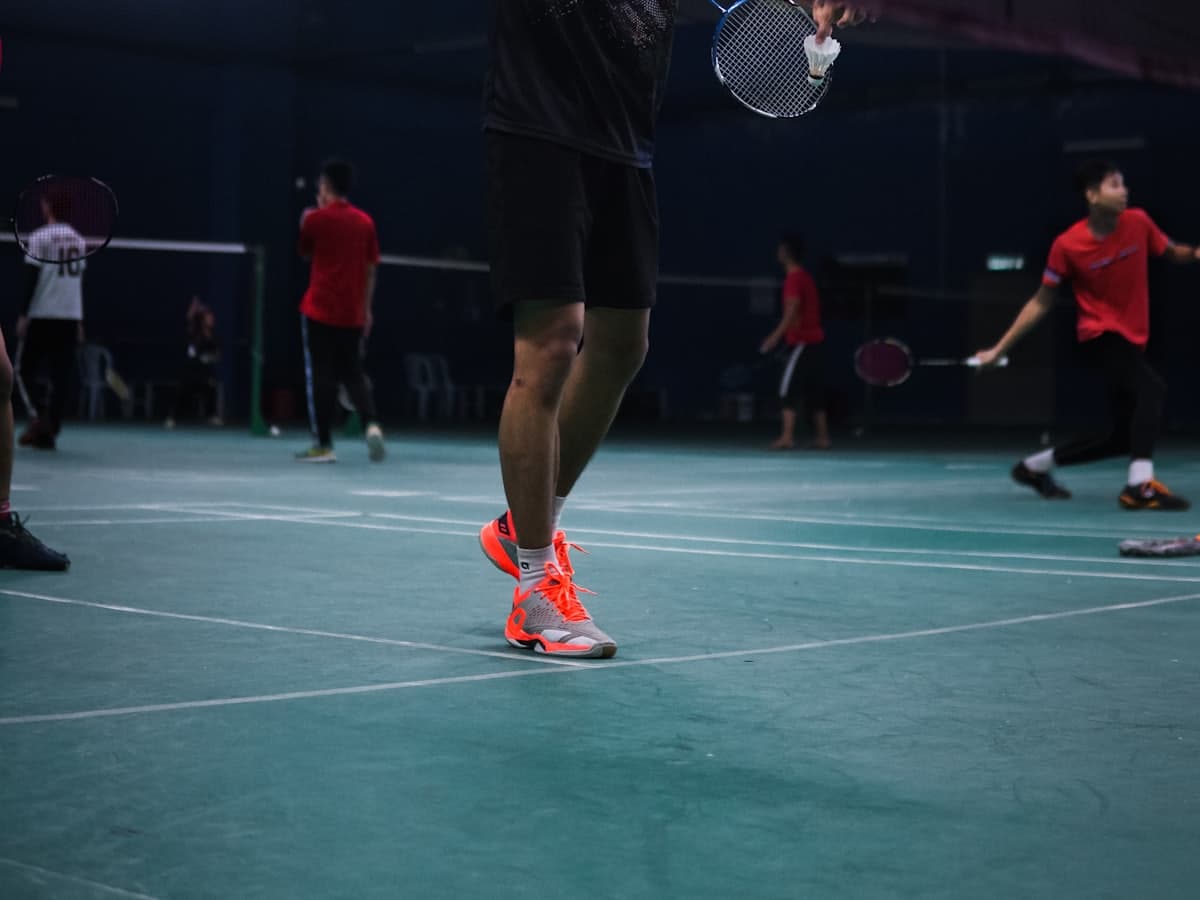 A badminton rally on an indoor court